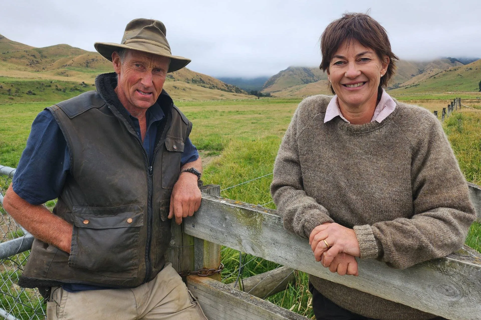 Anna and Kate's parents, Fiona and James Macdonald leaning on a fence