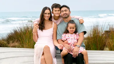 Ameliaranne with her husband and kids in front of the beach