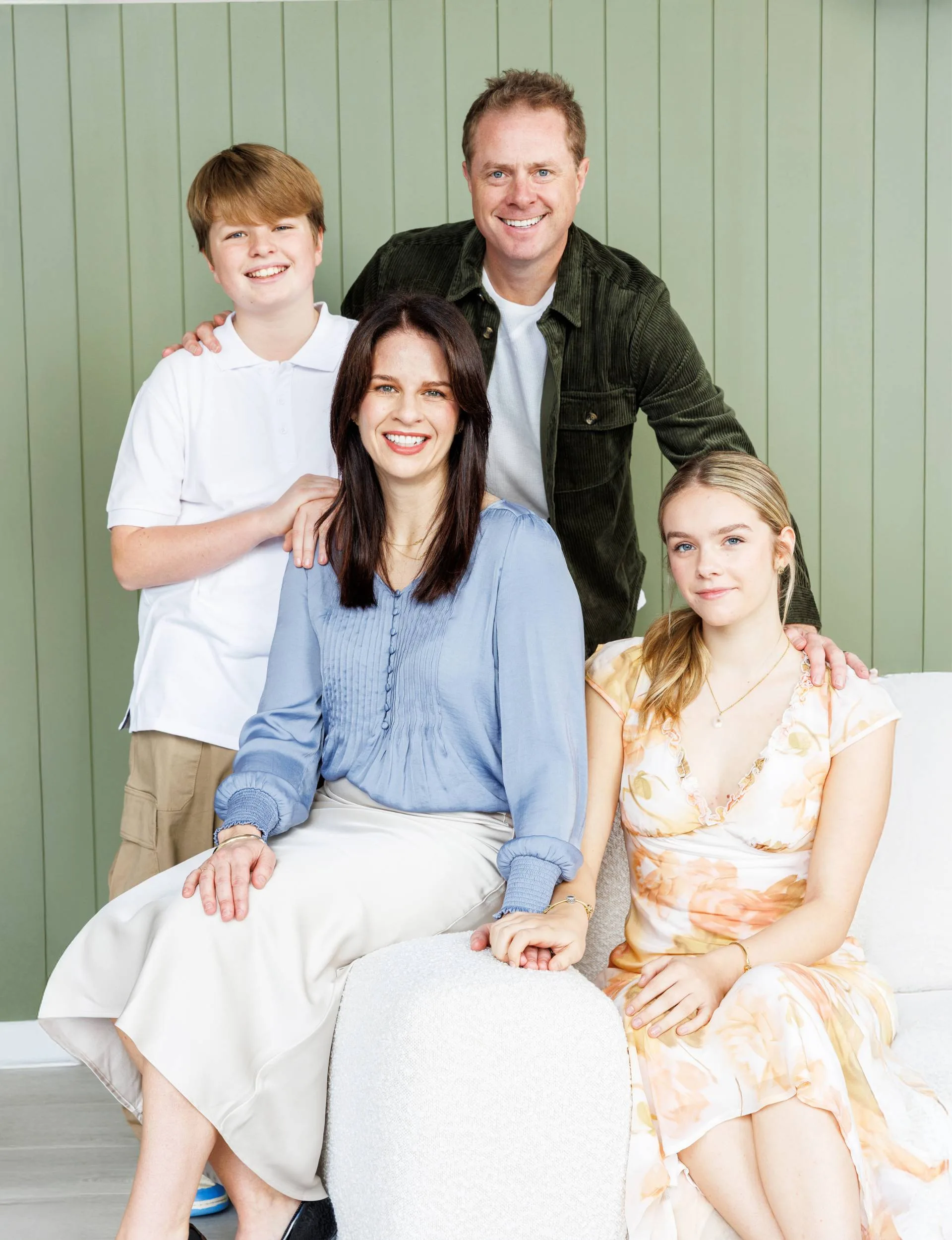 Erica Poppelbaum with her family in front of a green wall