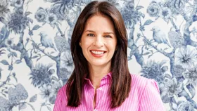 Erica Stanford in front of a blue and white wallpapered wall