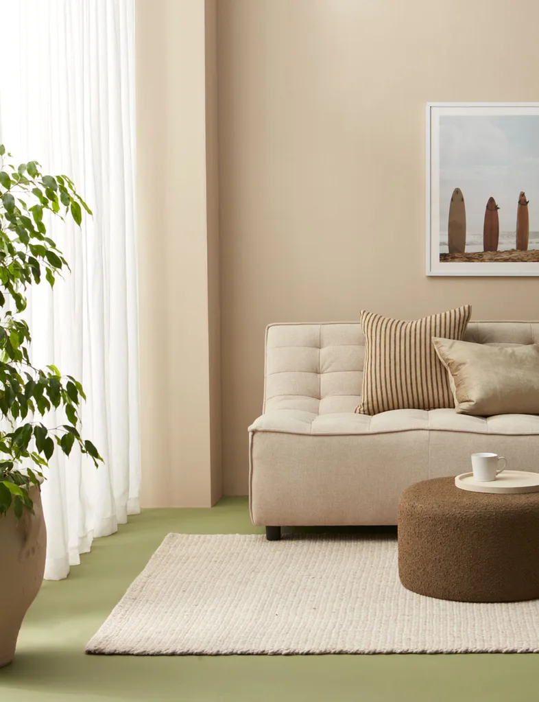 The use of a muted biophilic green on the floor livens up the restrained palette in this neutral room and connects it more closely to the natural world.