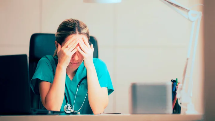A female nurse with her head in her hands
