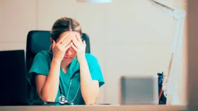 A female nurse with her head in her hands