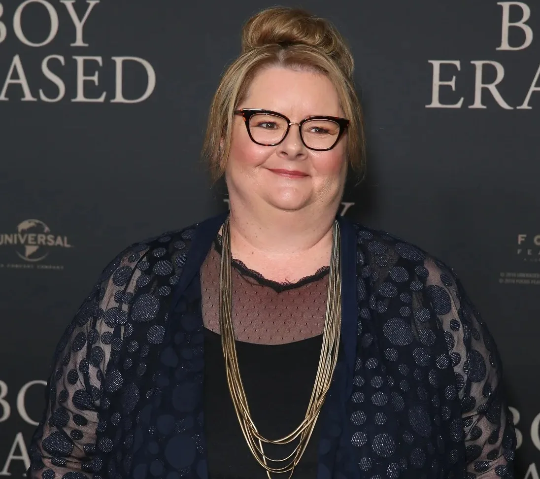 magda szubanski on red carpet wearing black dress and large gold necklace