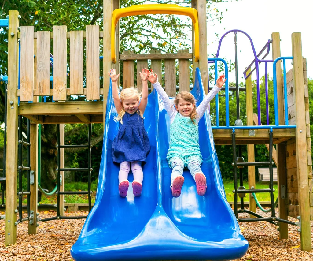 two kids going down slide