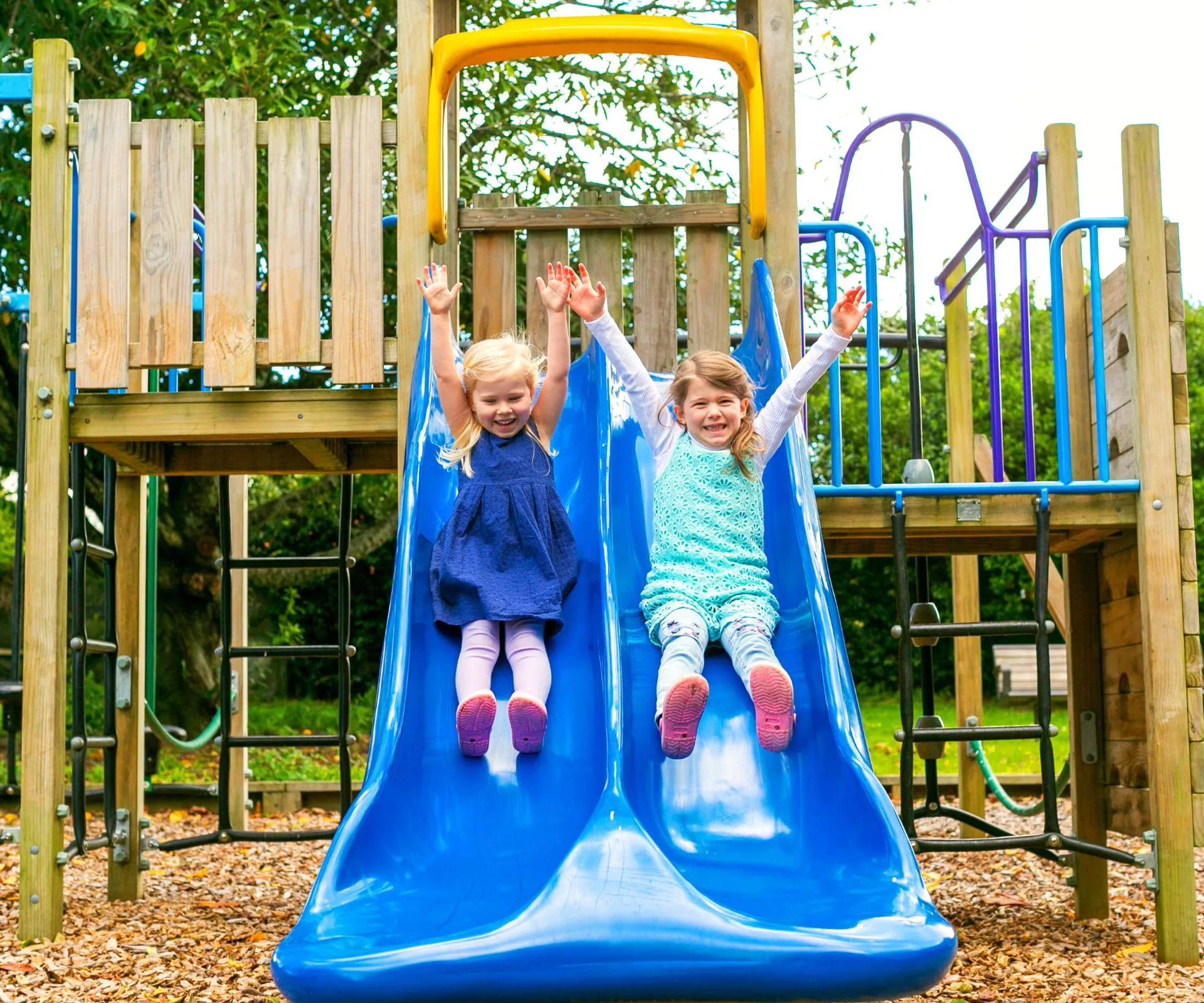 two kids going down slide

