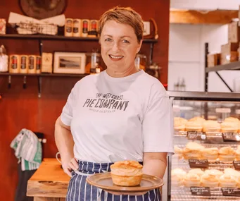 emily lucas in the front of her west coast pie co bakery holding a pie