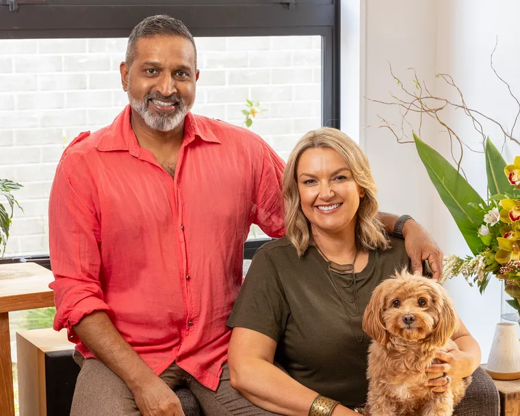 ganesh raj and wife jo sitting on couch with their dog
