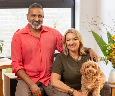 ganesh raj and wife jo sitting on couch with their dog
