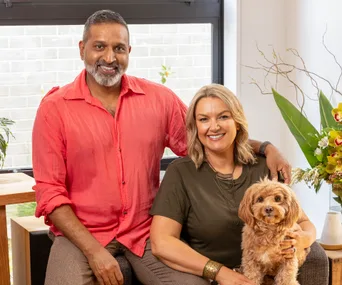 ganesh raj and wife jo sitting on couch with their dog