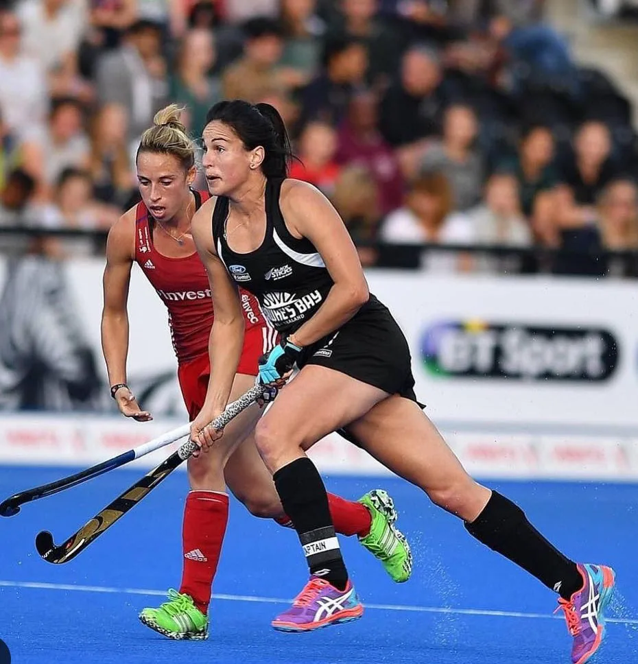 Kayla Whitelock playing hockey on blue hockey turf