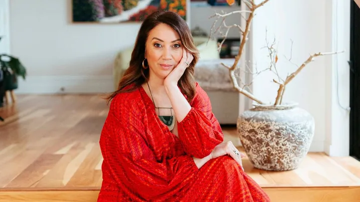 miriama kamo sitting on stairs wearing red dress