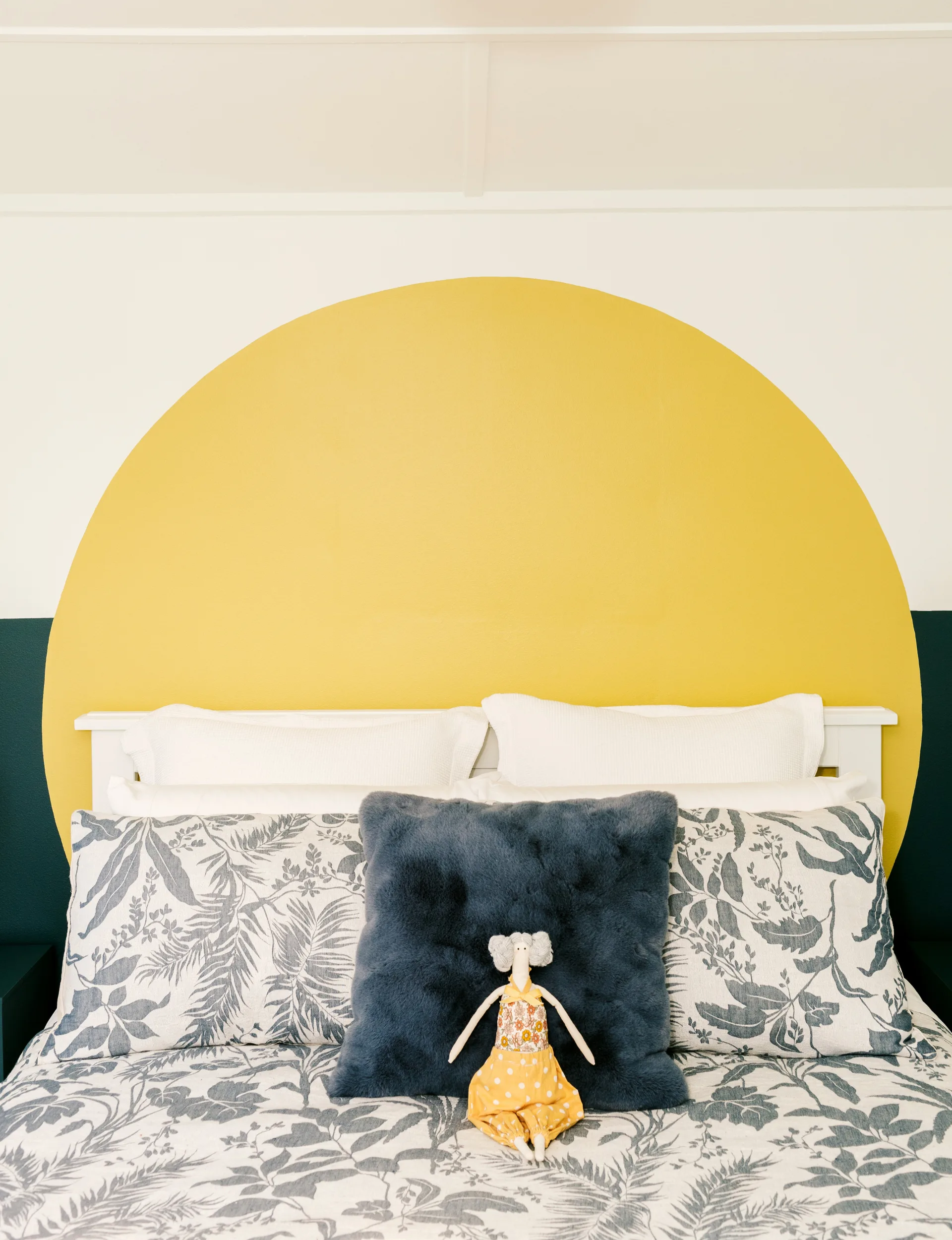 A circle of yellow paint pops against the dark green and neutral paint in one of the bedrooms in the 2025 Resene Colour Home Awards winning home