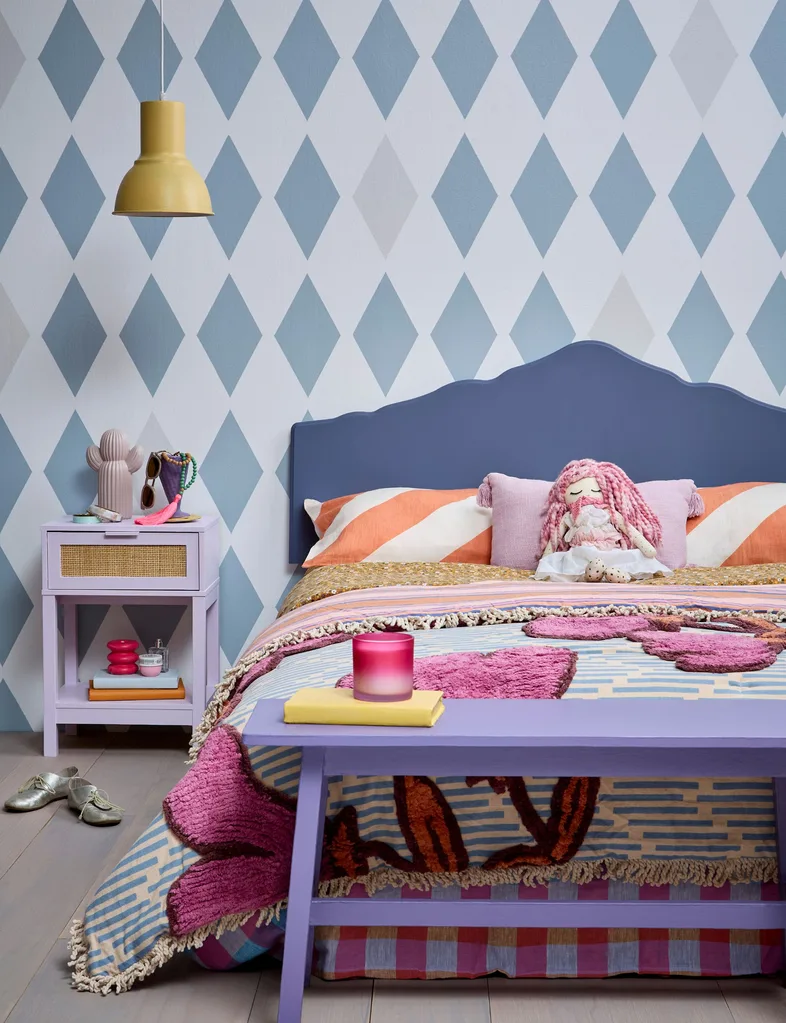 A fun feature wall in this teen bedroom is created with a diamond pattern using different shades of blue. The rest of the room decor are in shades of pinks and purples