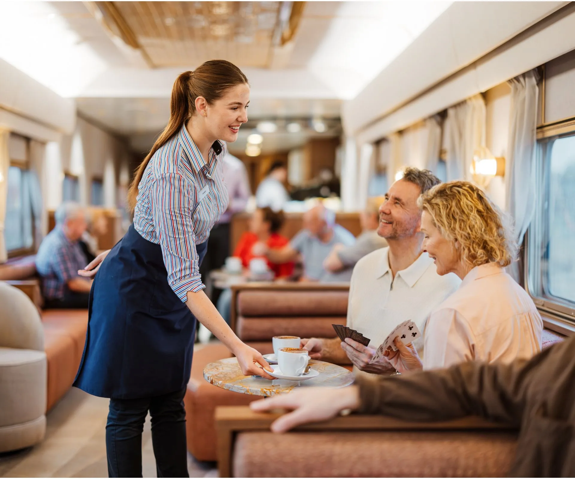 A waitress delivering coffee to a couple in the Gold Premium Lounge