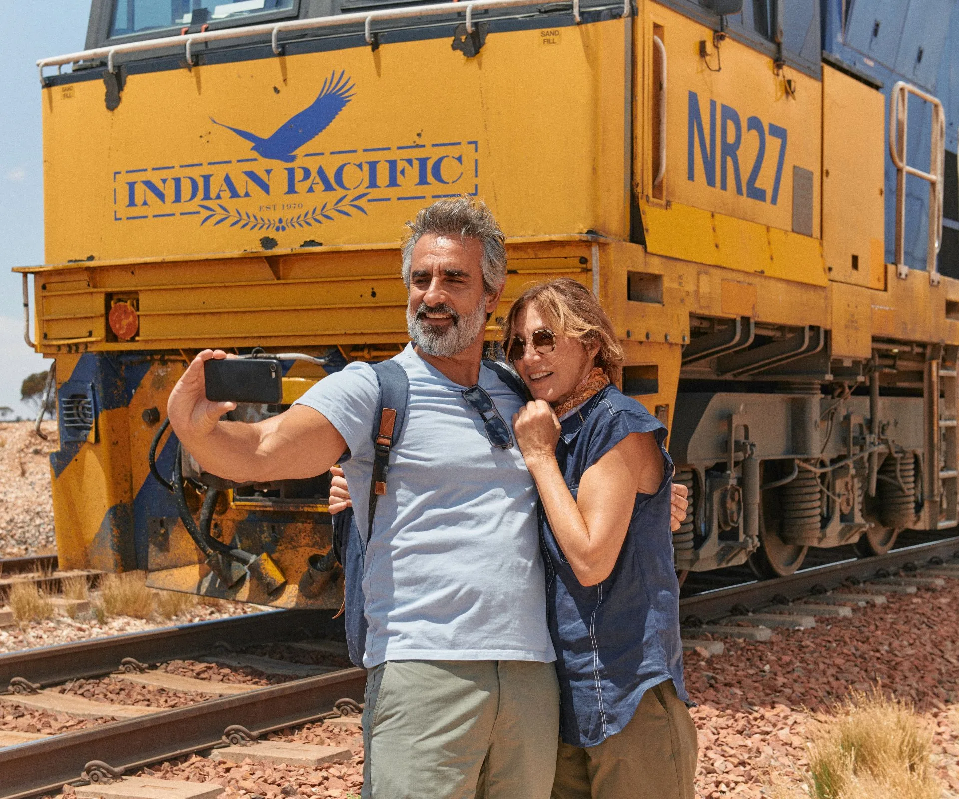 Couple taking a selfie in front of the Indian Pacific train