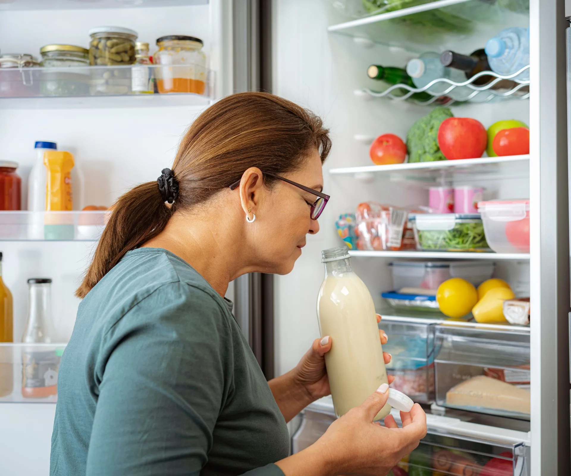 woman sniffing milk to see if it's expired
