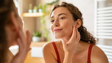 Woman checking her skincare in the mirror