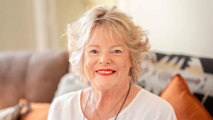 Cherly Sands smiling in a bright living room