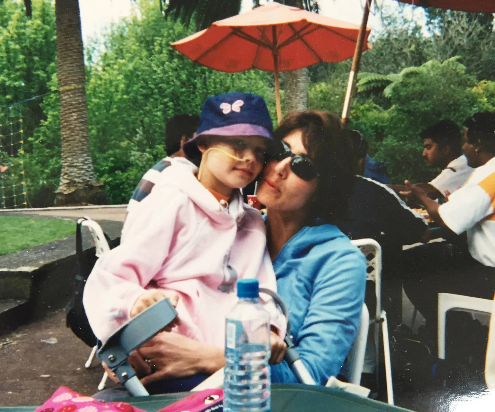 kid sitting on mothers lap outside