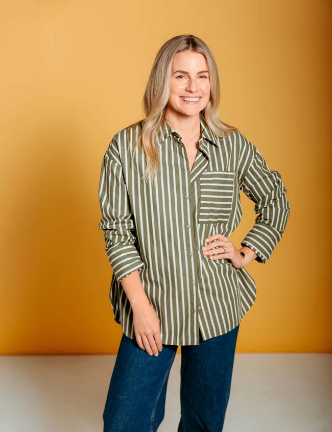 woman in green and white shirt smiling