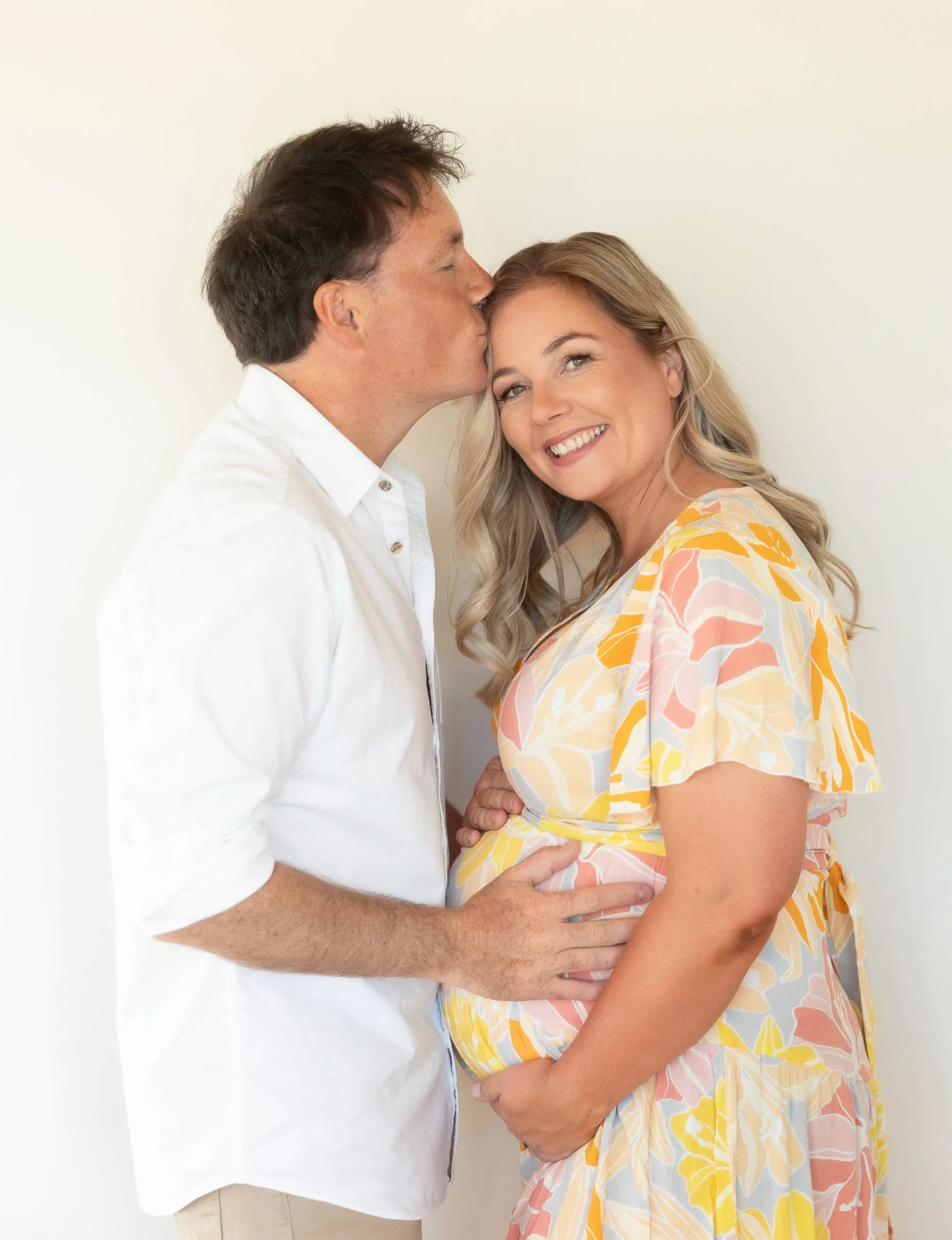 Alexa Cook and partner posing together holding baby bump