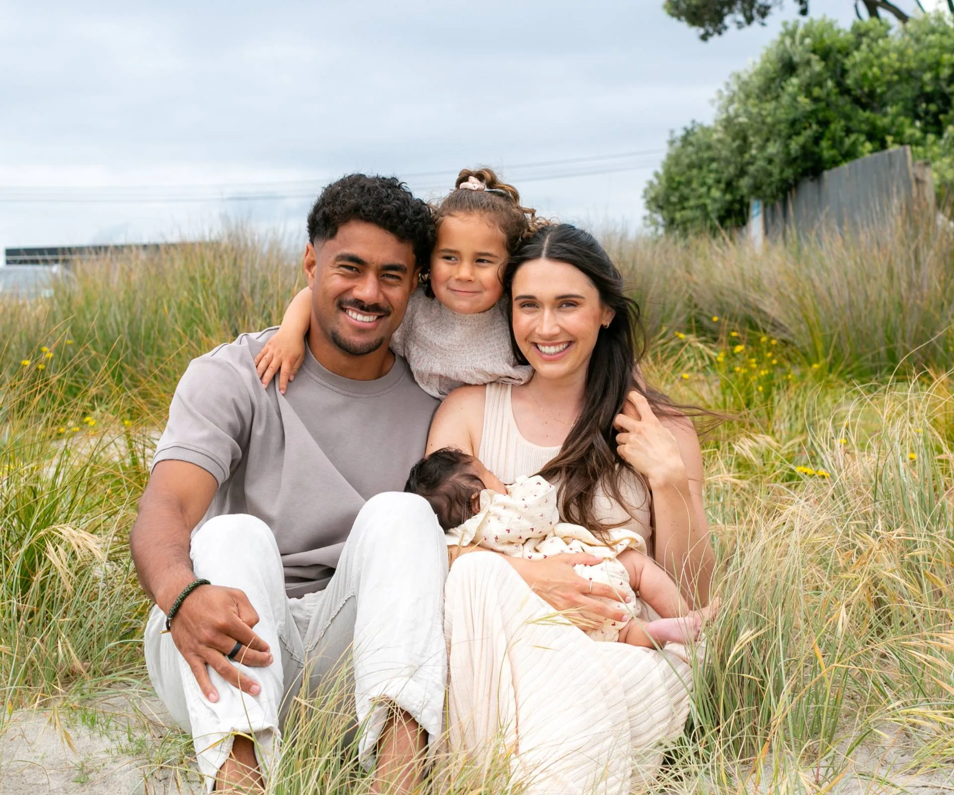 emoni and family sat on the beach together smiling