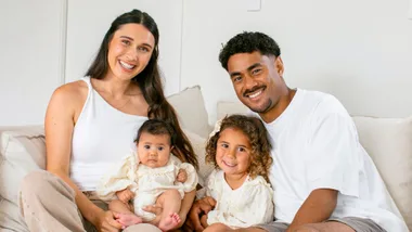 Emoni and family sat on couch smiling