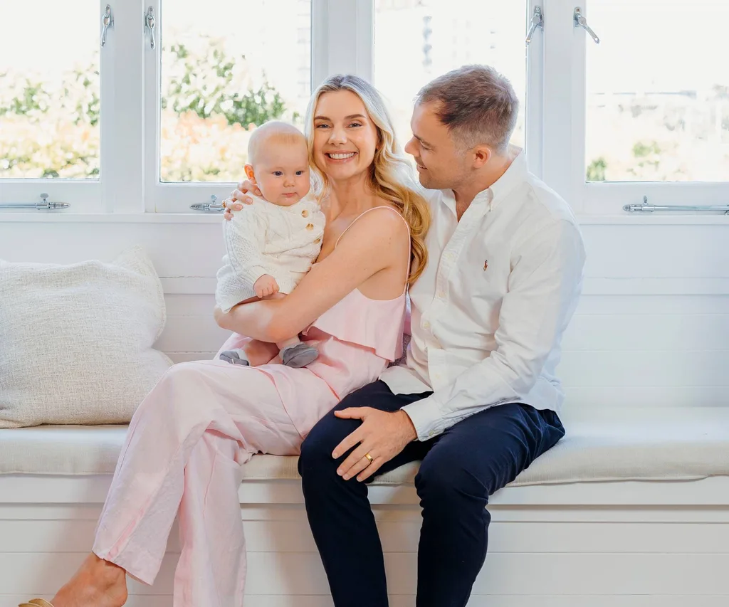 Caitlin Crisp and partner with baby Charlie sat together by window sill