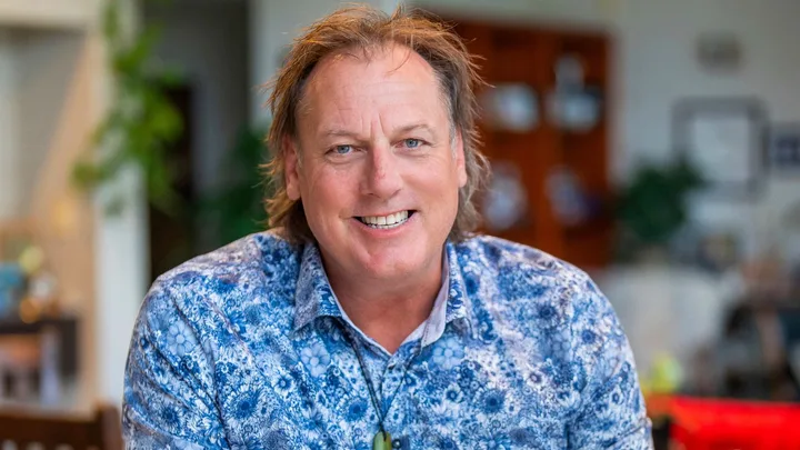man in blue pattern shirt smiling