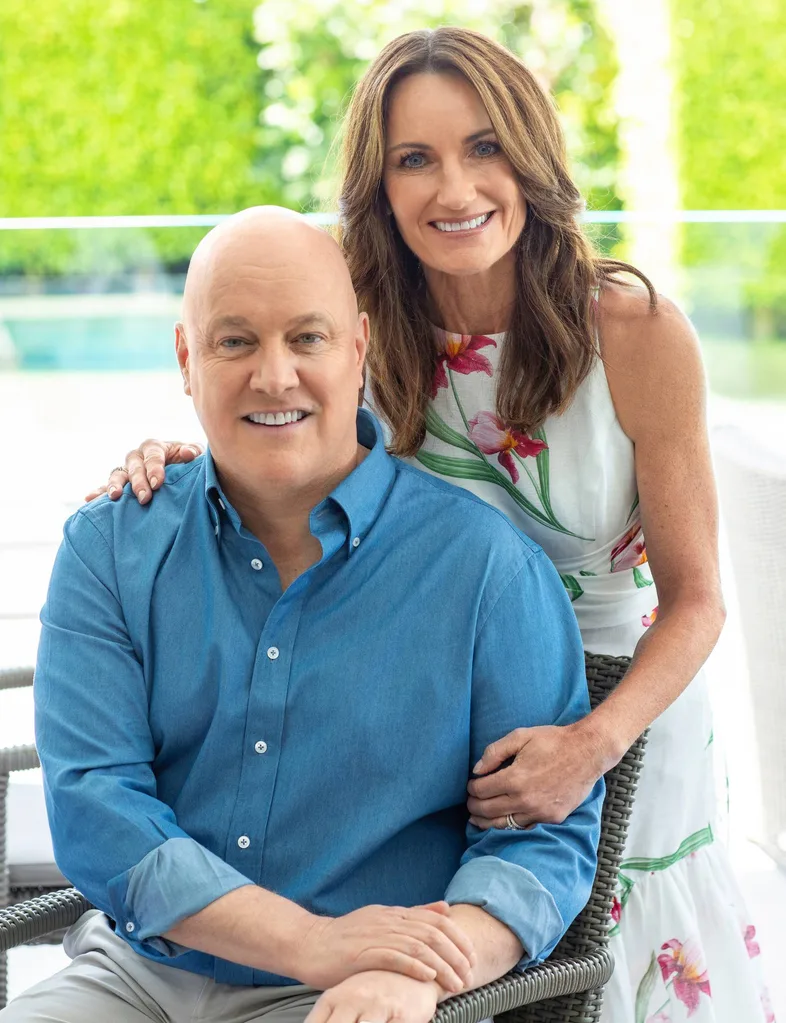 Man in blue button up and woman in floral dress smiling
