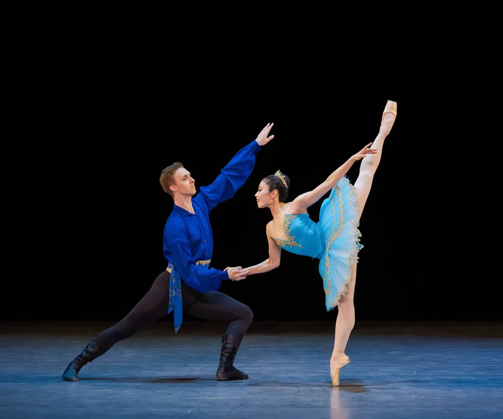 Ballerina in blue tutu and man in blue shirt dancing