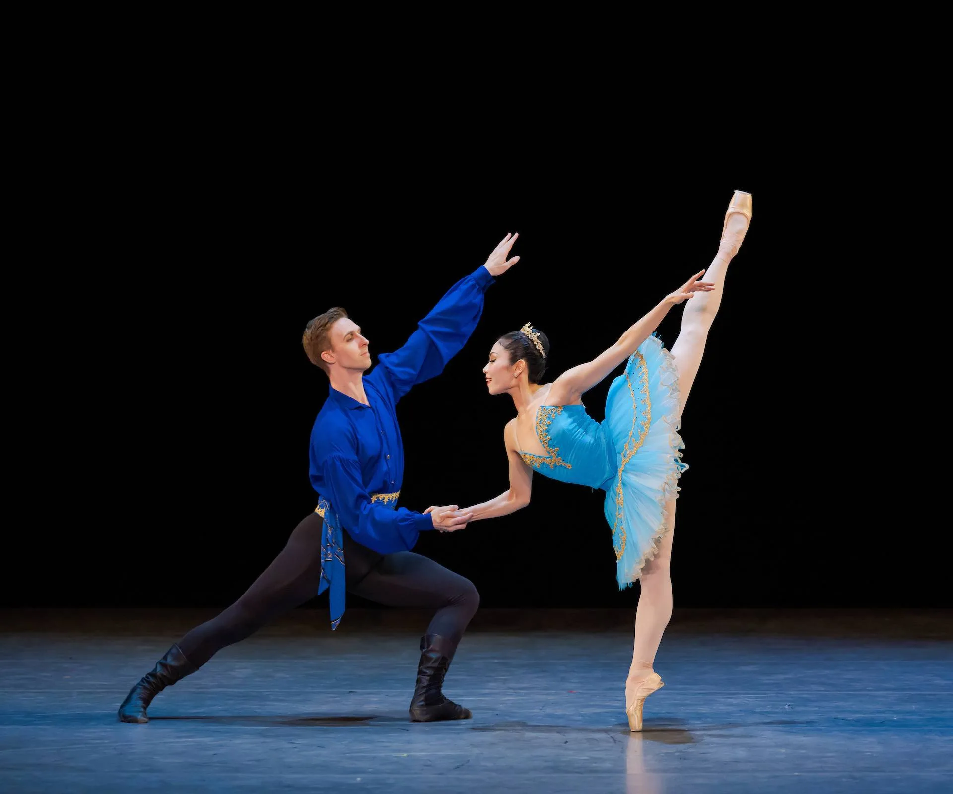 Ballerina in blue tutu and man in blue shirt dancing