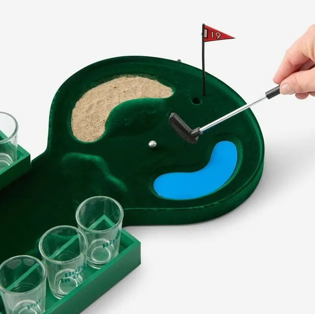 miniature golf green with miniature clubs and ball and shot glasses