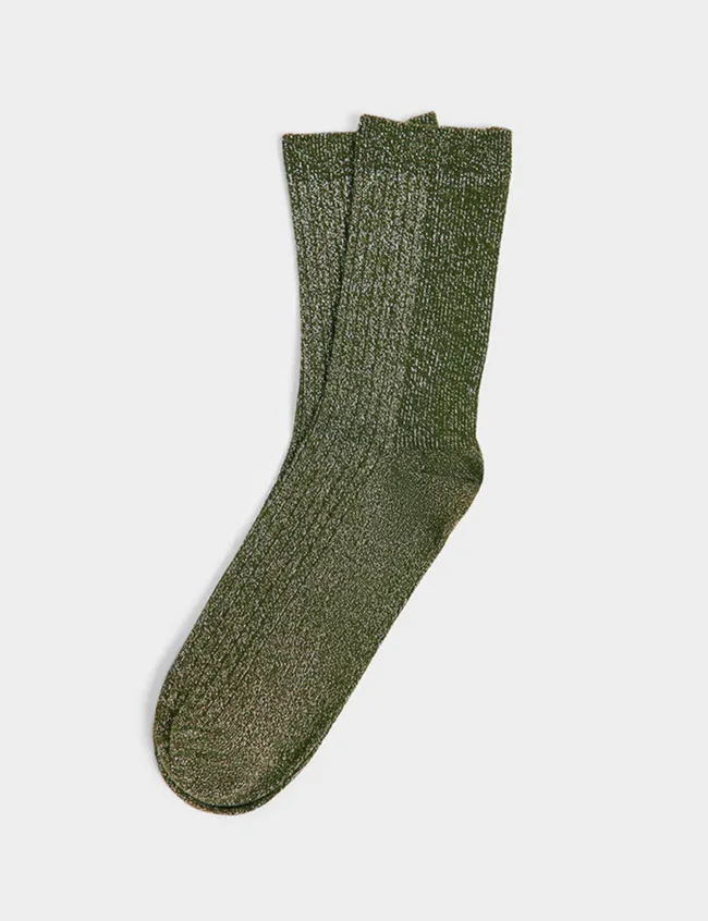 Pair of sparkly green socks against a grey background