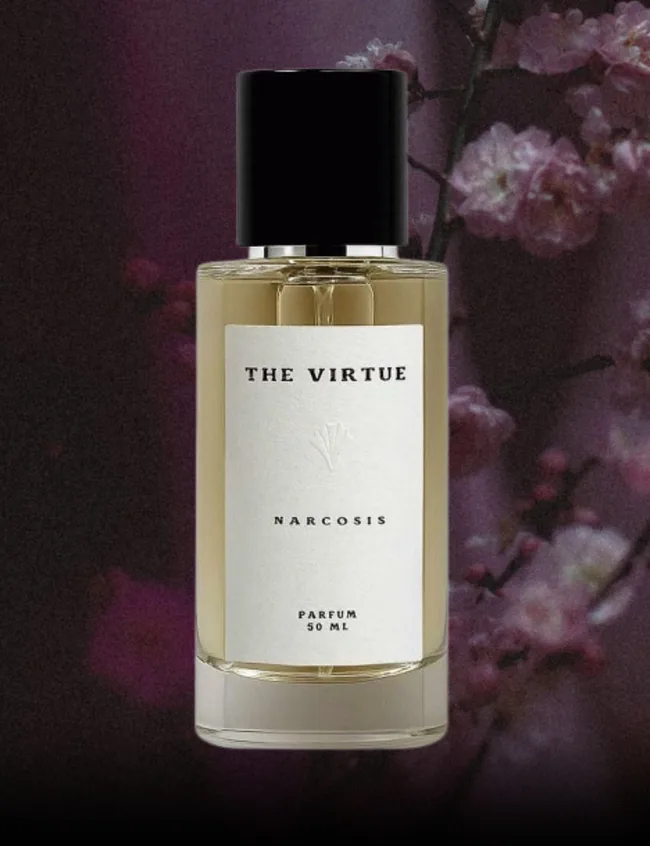 Glass perfume bottle with white label and minimal text, set against dark purple floral background