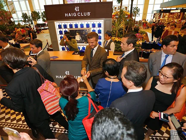 Celebrity greeting fans at a Haig Club event, surrounded by a crowd taking photos.