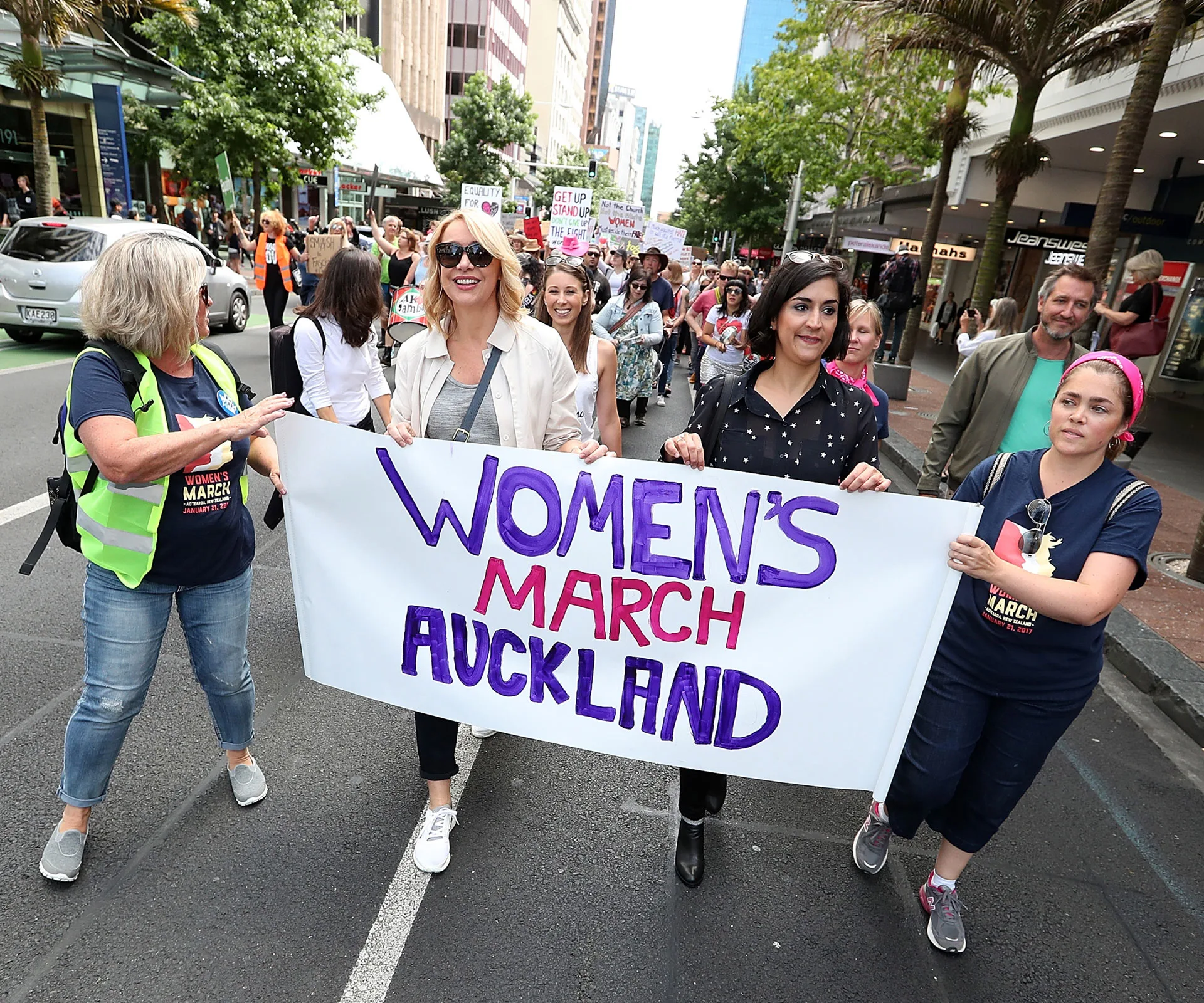 Lizzie Marvelly (in white sleeveless top) walks behind broadcaster Ali Mau (at front in sunglasses) along Auckland’s Queen Street on January 21, in a global show of solidarity with those marching in Washington DC.