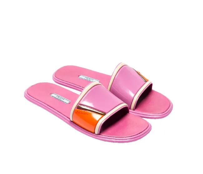 Pink and orange slide sandals with textured soles and glossy straps, isolated on a white background.