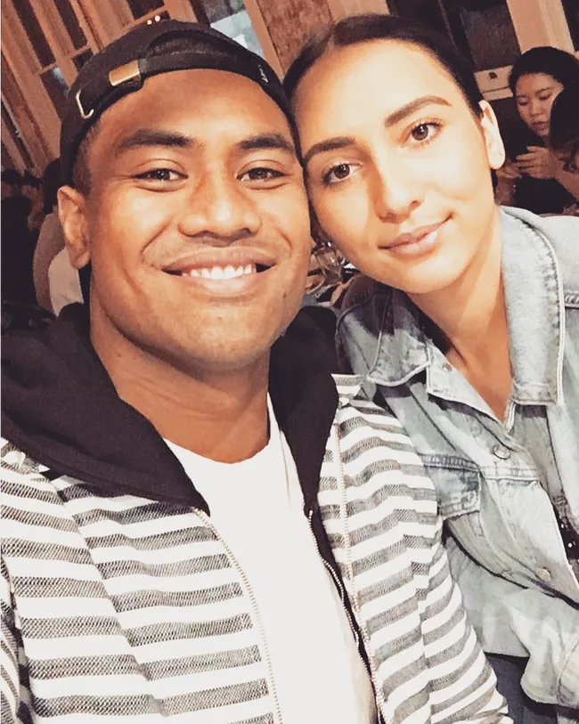 A man in a striped jacket and a woman in a denim jacket smiling together for a selfie.