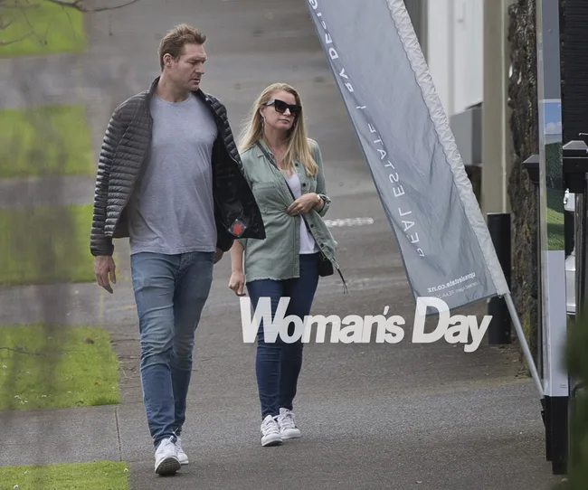 Two people walking down a sidewalk with a "Woman's Day" logo overlaid, one wearing sunglasses.