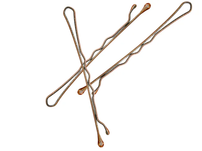 Three rusty bobby pins arranged on a white background.