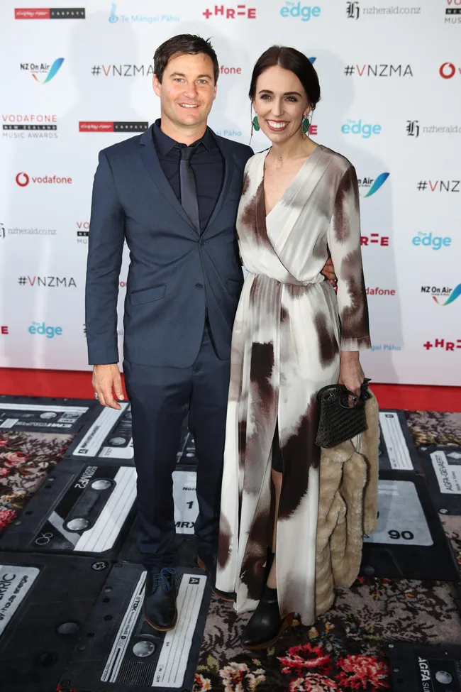Two people smiling on the red carpet at the Vodafone New Zealand Music Awards, with logos in the background.