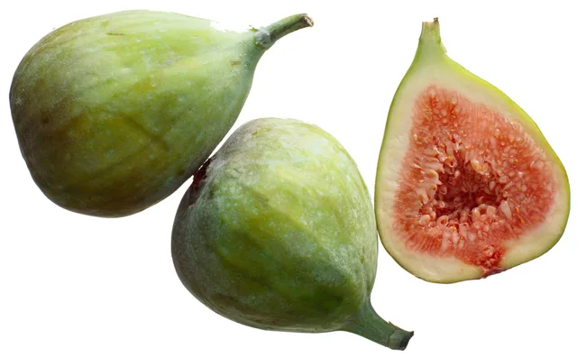 Fresh figs including one sliced in half, showing pink interior and seeds, on a white background.