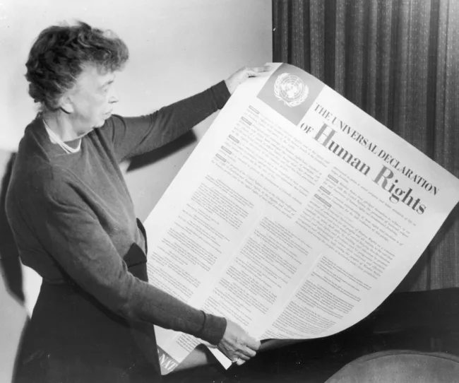 Woman holding the Universal Declaration of Human Rights poster.