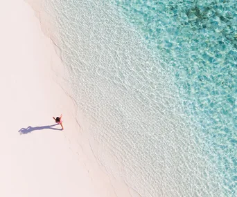 woman walking on a beach, birdseye shot