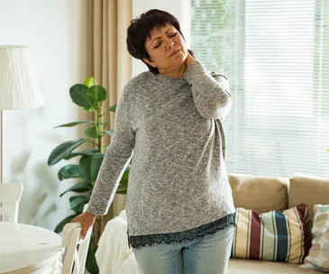 Woman holding and stretching sore neck