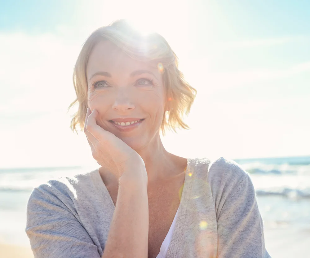 mature woman smiling at beach