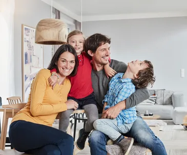 Happy family portrait on couch with dogs