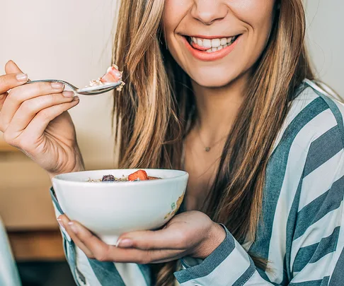woman eating a bowl of muesli